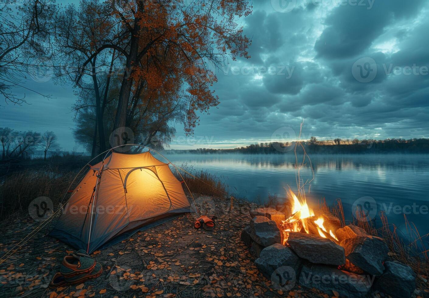 Camping tent on the shore of a lake at dusk photo