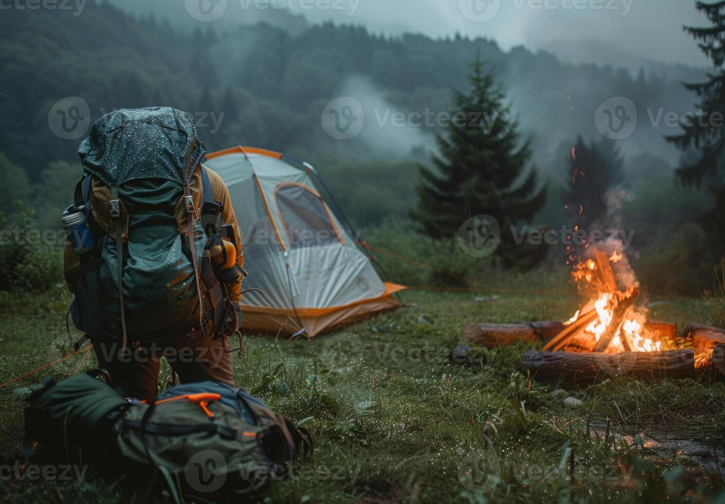 A person with a backpack and a tent near a campfire photo