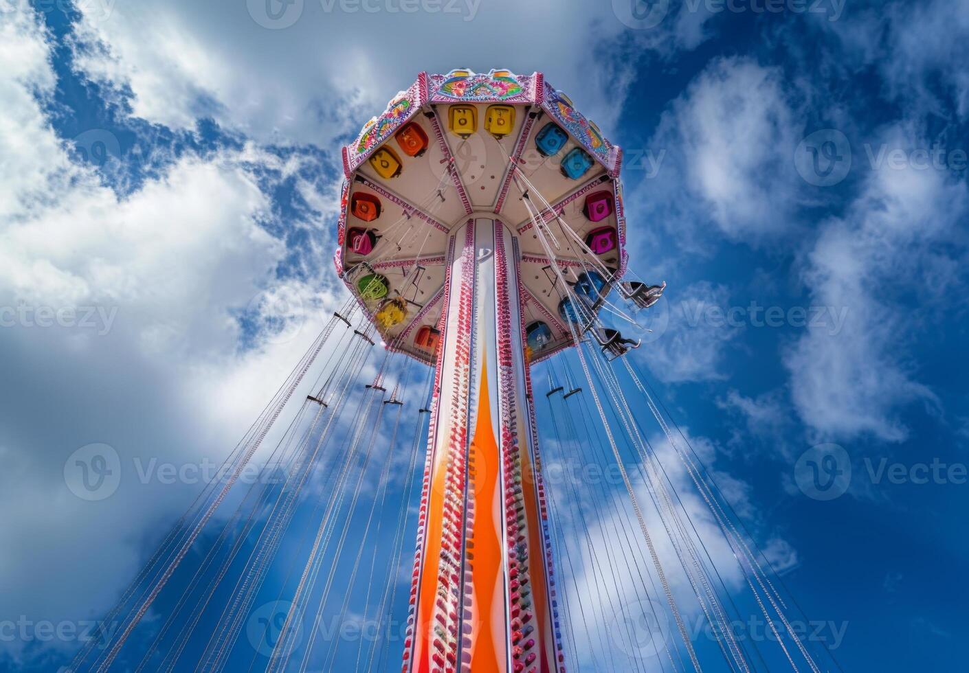 A carnival ride with colorful seats and a blue sky photo