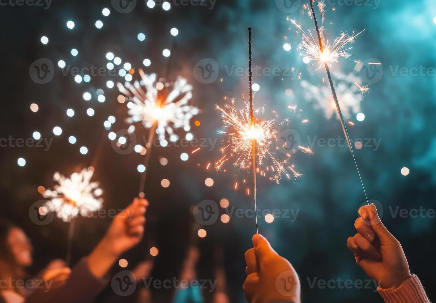 Fireworks illuminating a festive scene, with people holding sparklers in the foreground, celebrating the New Year photo