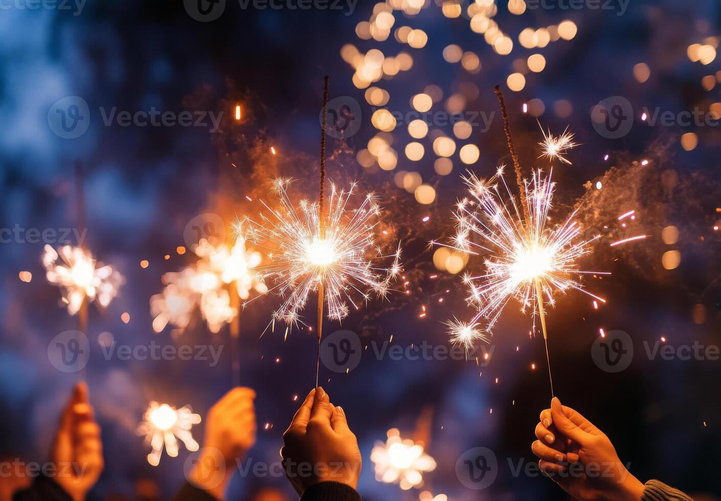 Fireworks illuminating a festive scene, with people holding sparklers in the foreground, celebrating the New Year photo