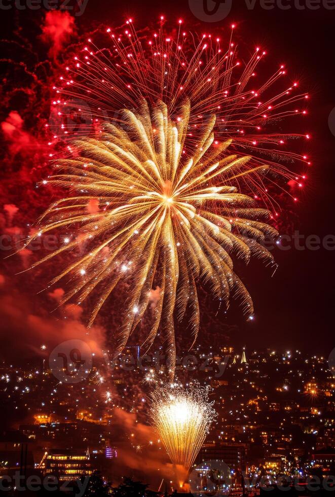 Golden and red fireworks spreading across the sky, with city lights twinkling in the background photo