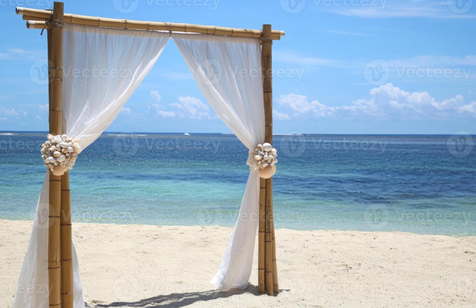A bamboo archway on the beach with white curtains photo