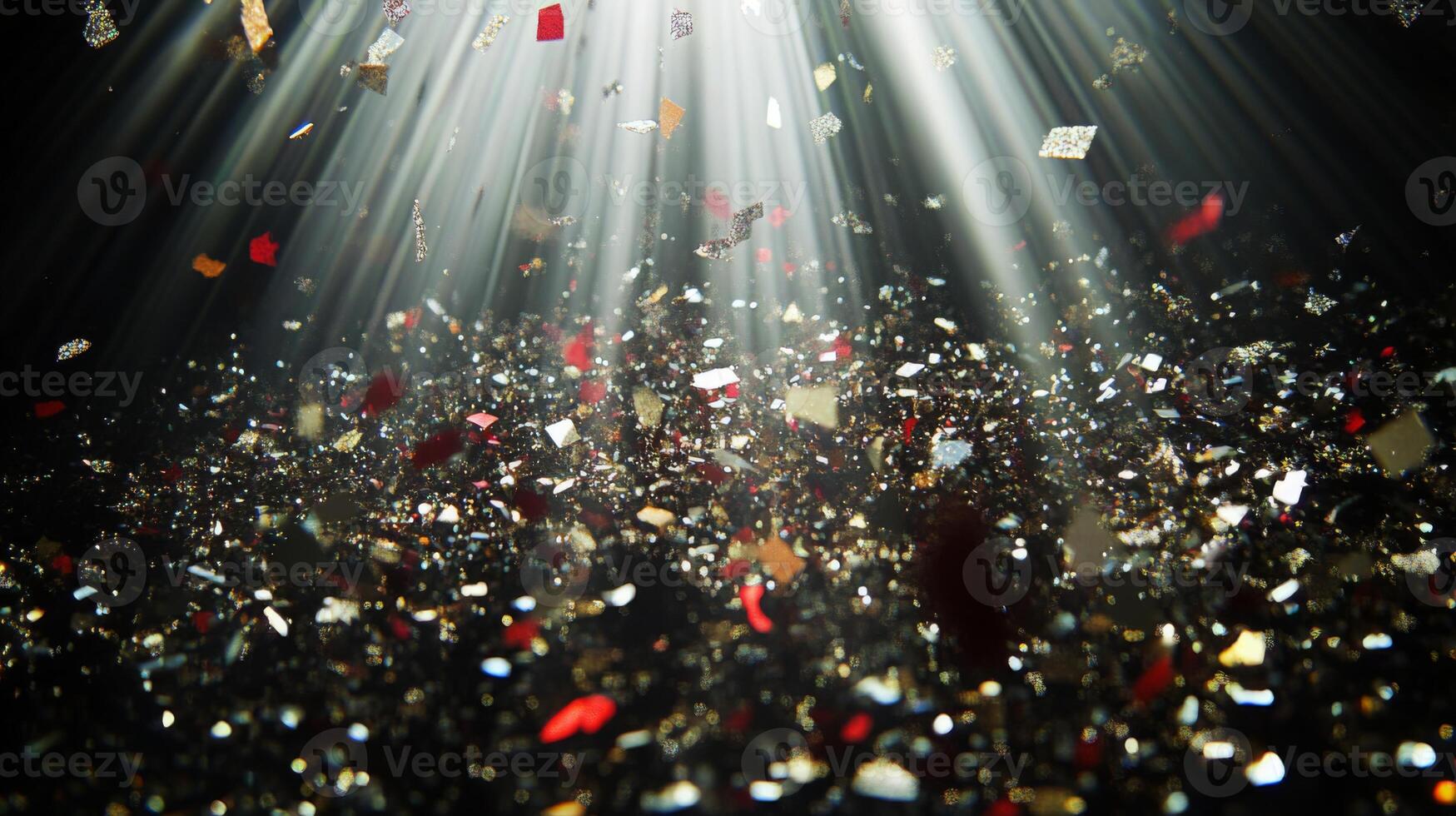 A shower of glittering confetti, highlighted by piercing light rays that create sharp contrasts between the bright pieces and the dark background photo