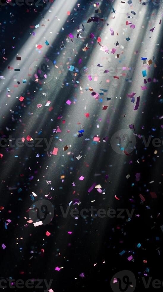 Soft, multicolored confetti drifting through shafts of light, with the dark background creating a stark, captivating contrast photo