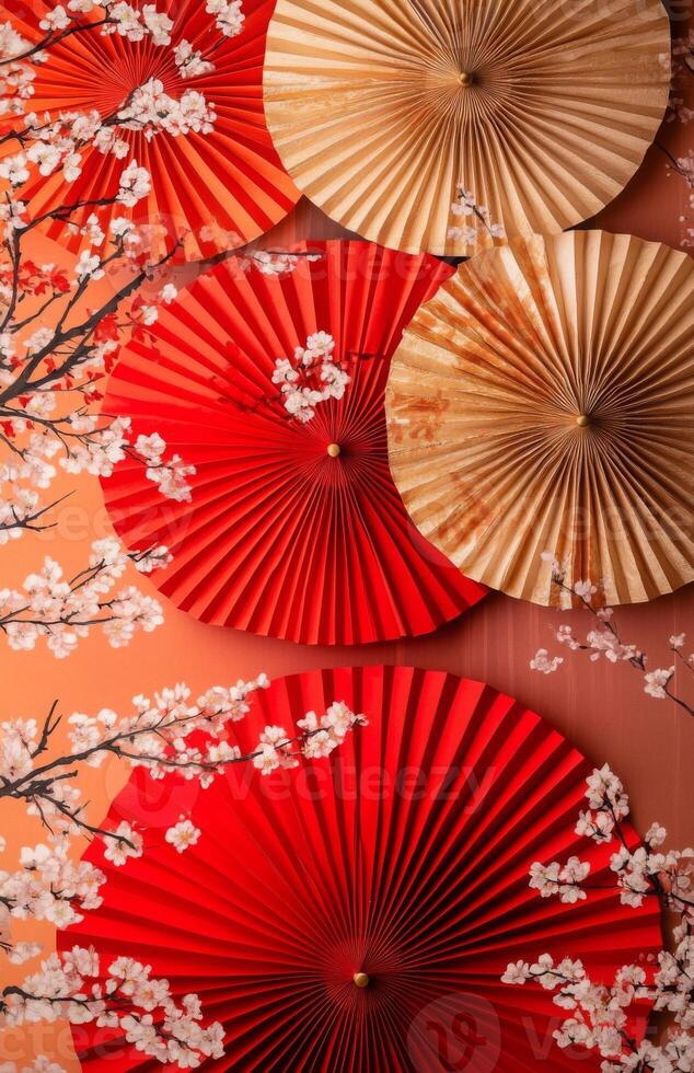 Red and white paper fans and cherry blossom branches photo