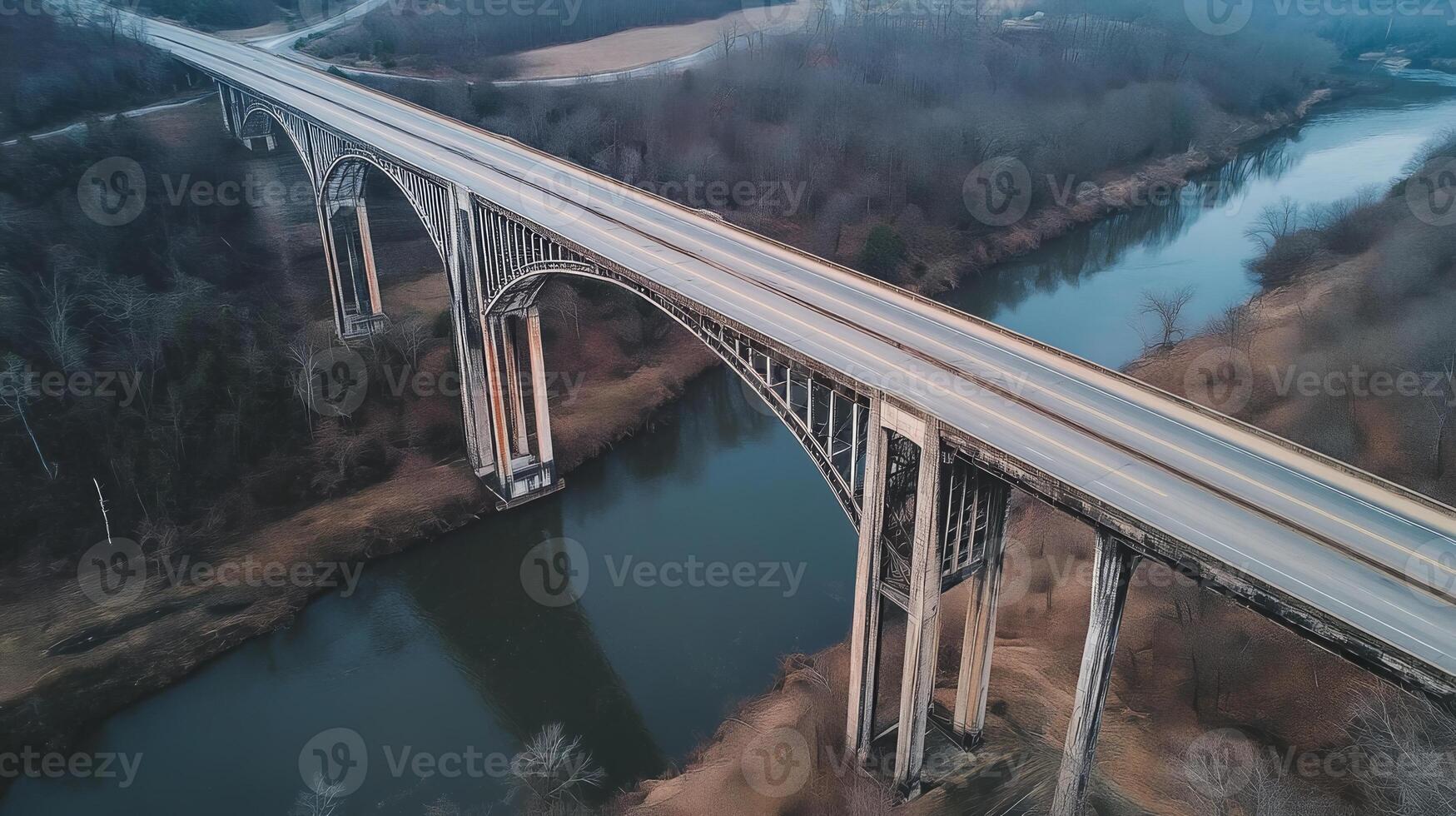 An expansive highway bridge crossing over a river, surrounded by nature and no signs of human activity photo