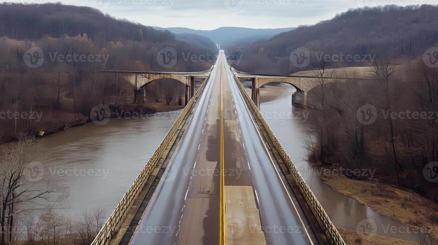 An expansive highway bridge crossing over a river, surrounded by nature and no signs of human activity photo
