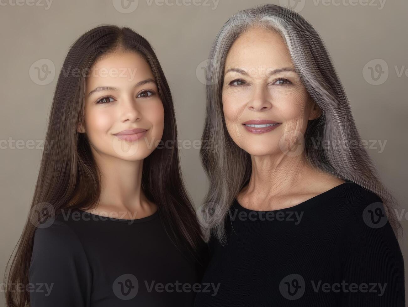 Portrait of two beautiful women, one younger and one older, standing side by side, smiling, with a soft neutral background photo