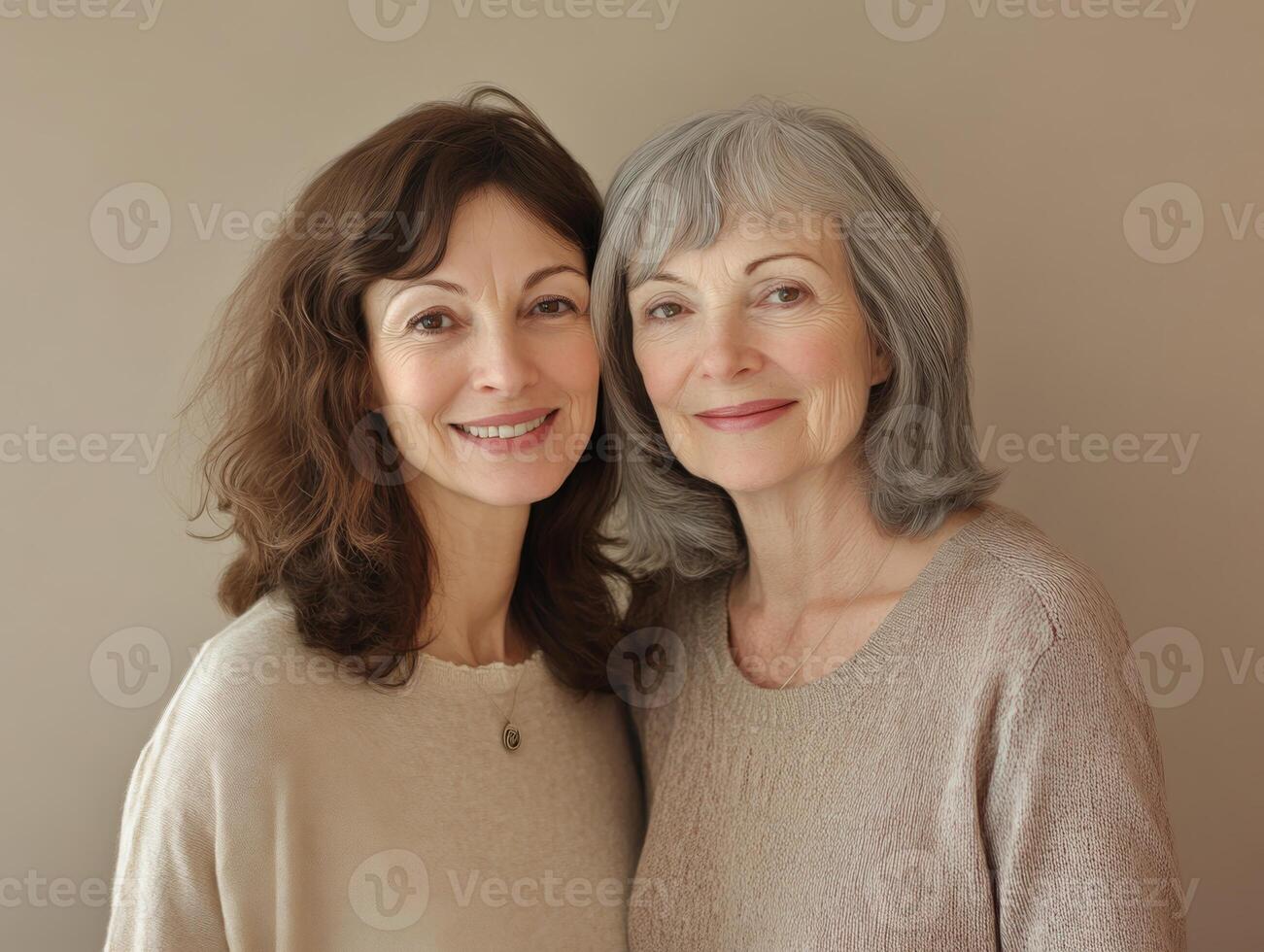 Two women, one in her thirties and one in her sixties, standing close together with soft smiles, against a neutral-toned background photo