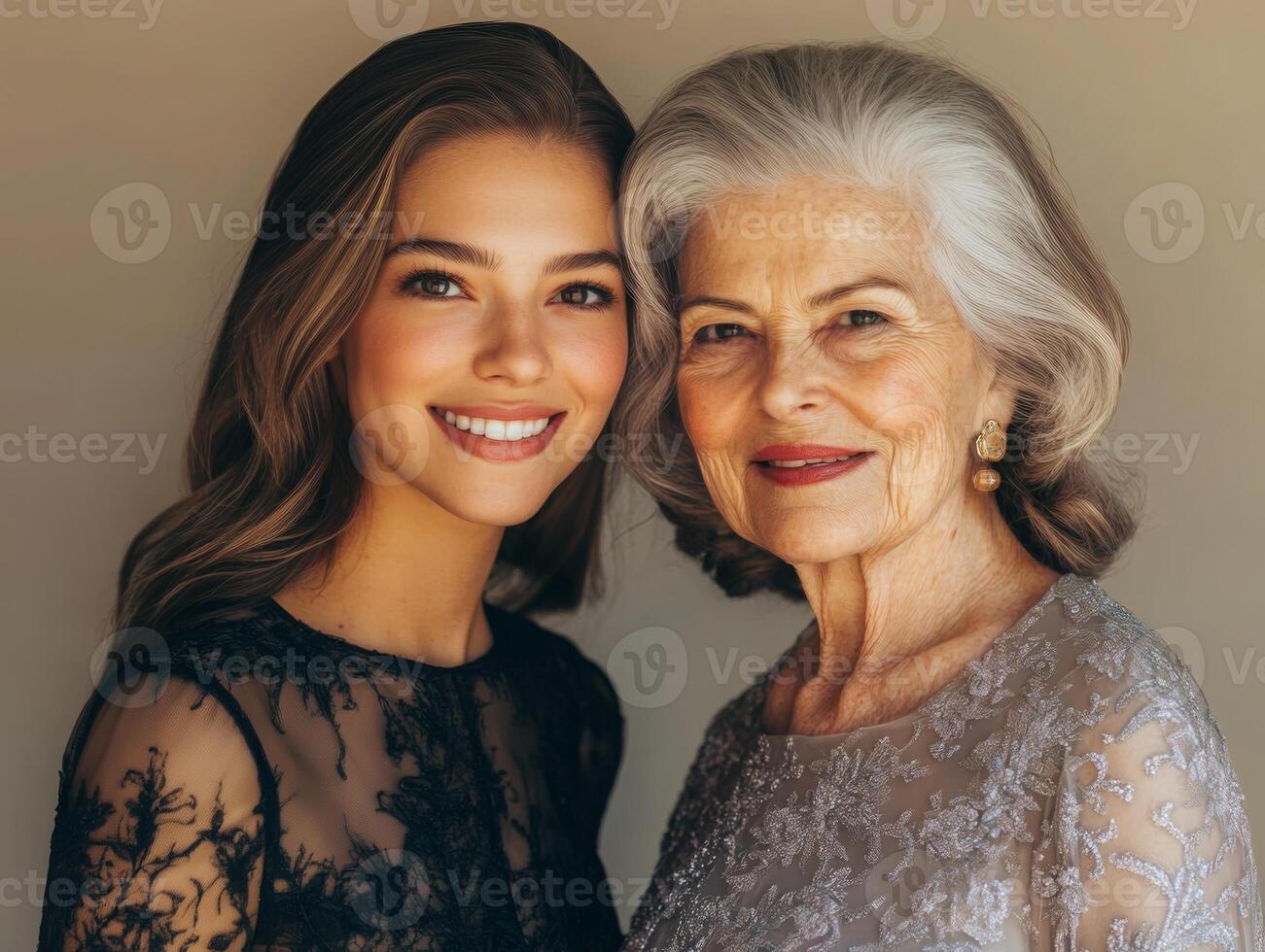 A younger woman and an older woman, both beautifully dressed, standing together with subtle smiles, highlighting their different ages but shared grace photo