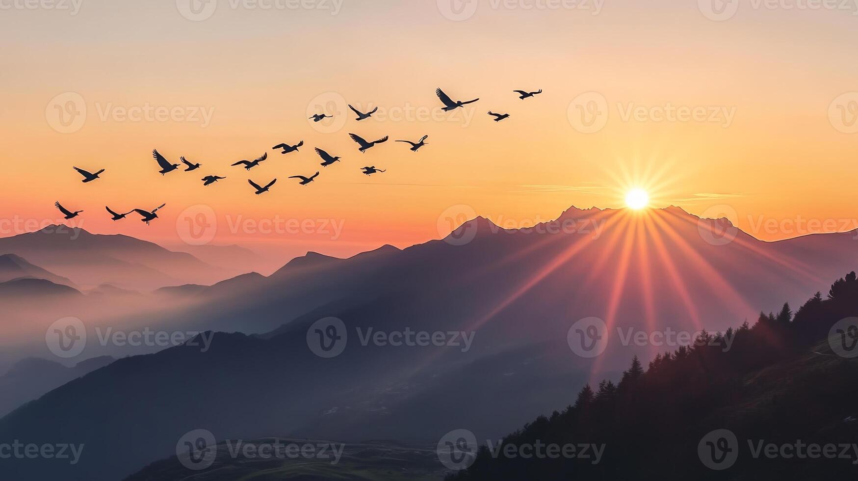 A flock of birds flying over a mountain range, silhouetted against the rising sun photo