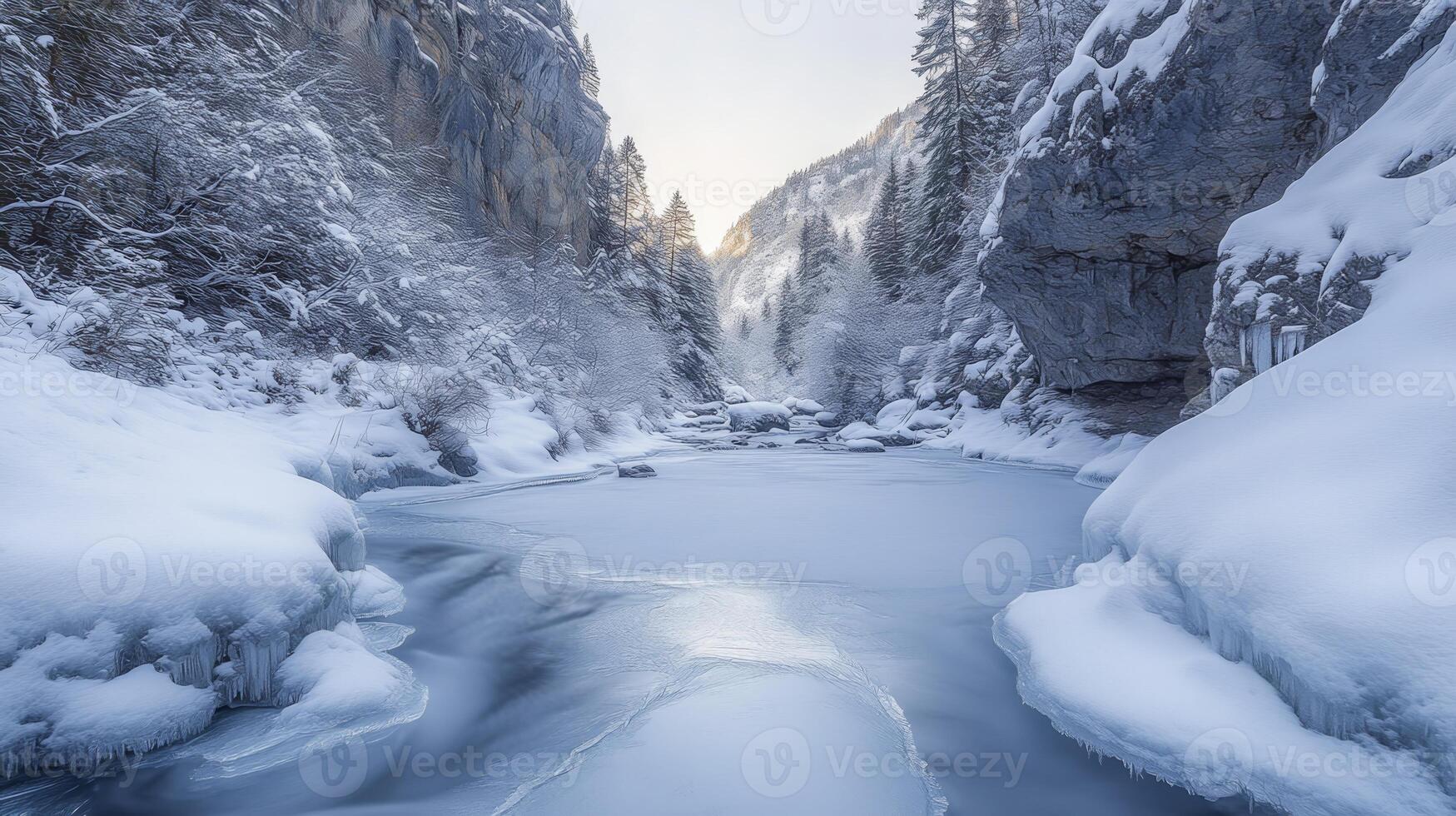 A tranquil snowy valley with a frozen stream running through it, surrounded by snow-covered trees and rocky cliffs photo