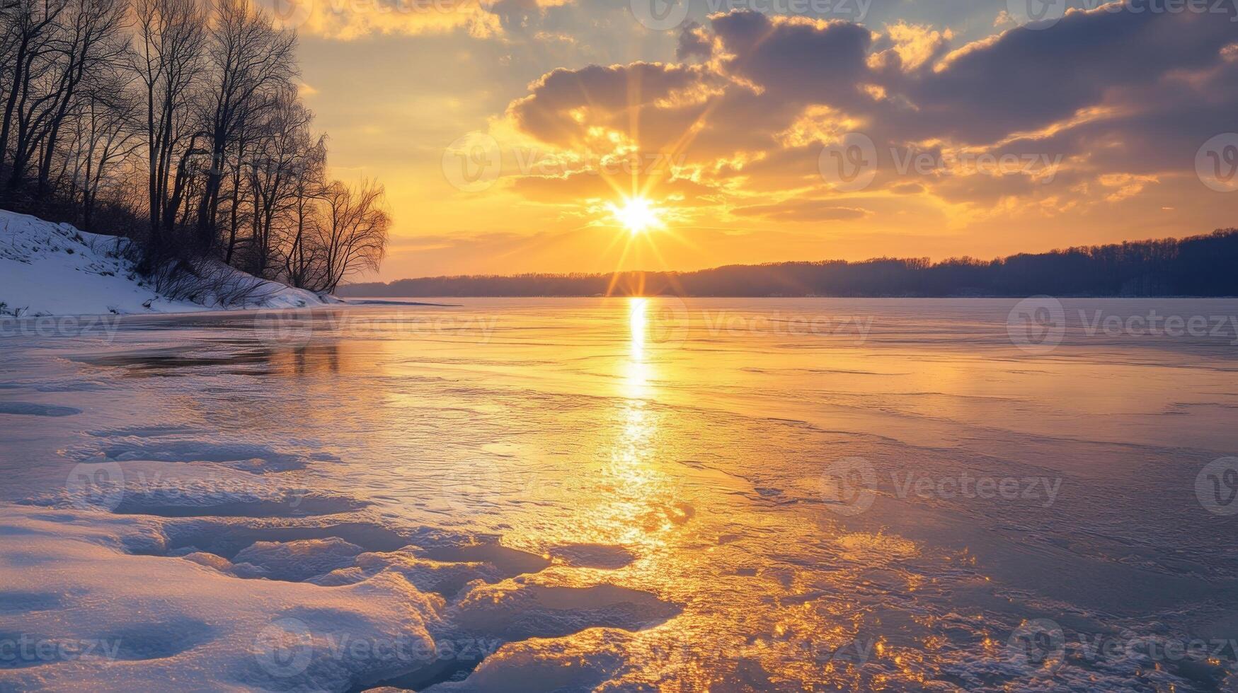 A winter sunset over a frozen lake, with warm golden light reflecting on the snow and ice photo