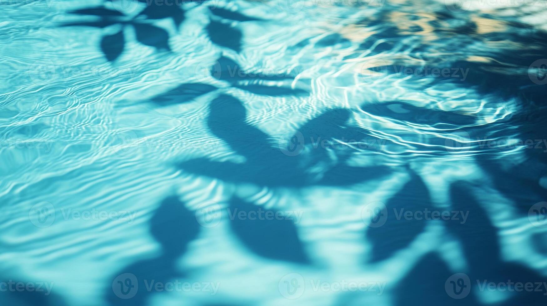 Blue water rippling with the movement of aqua waves, tropical leaves' shadows gracefully falling on the surface photo