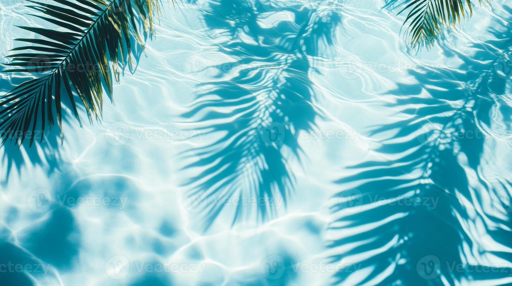 Crystal-clear aqua waves meeting shadows of broad tropical leaves on a sunlit blue pool texture photo