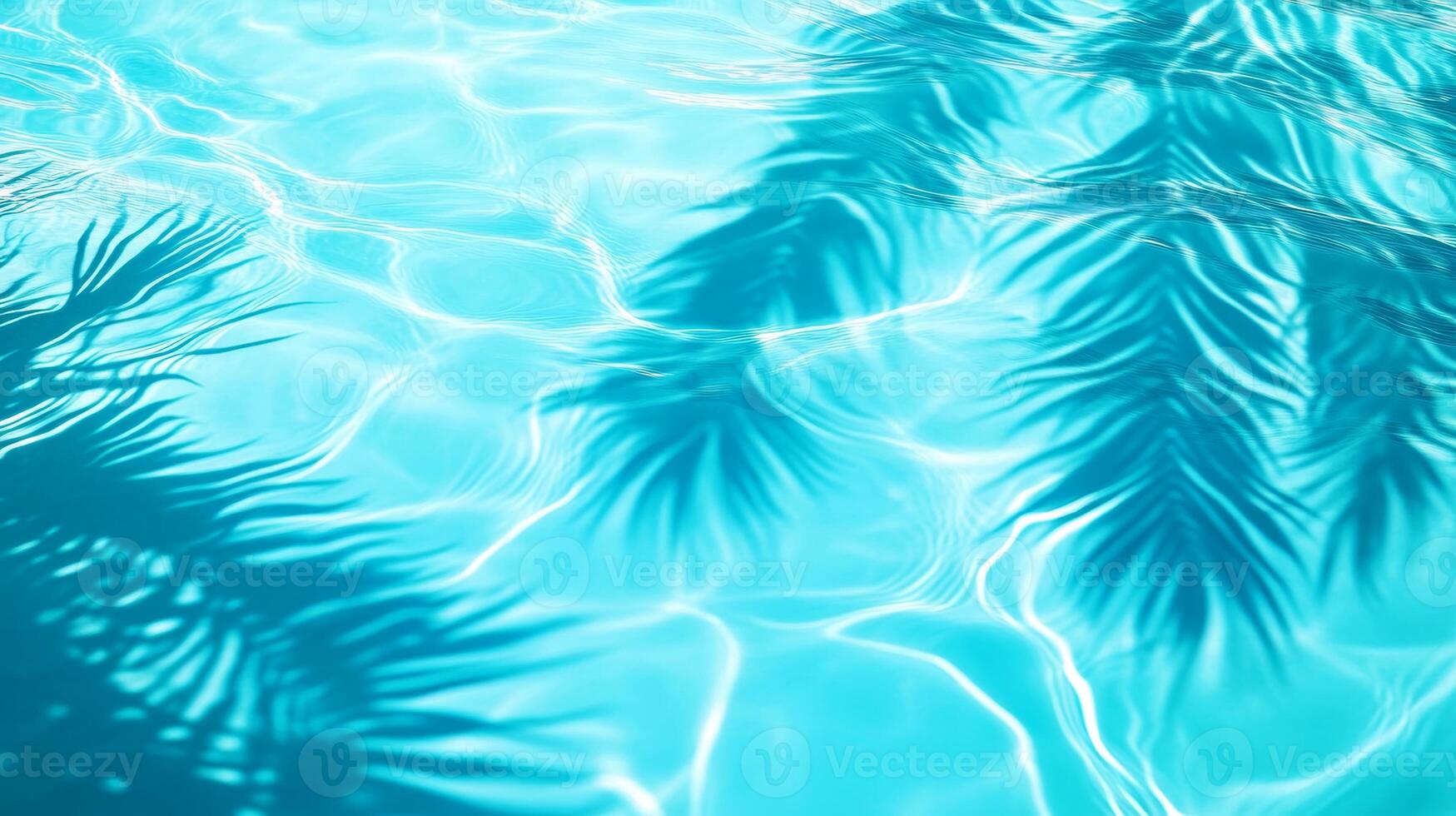 A detailed close-up of aqua waves with palm leaf shadows dancing on the surface of a bright blue pool photo