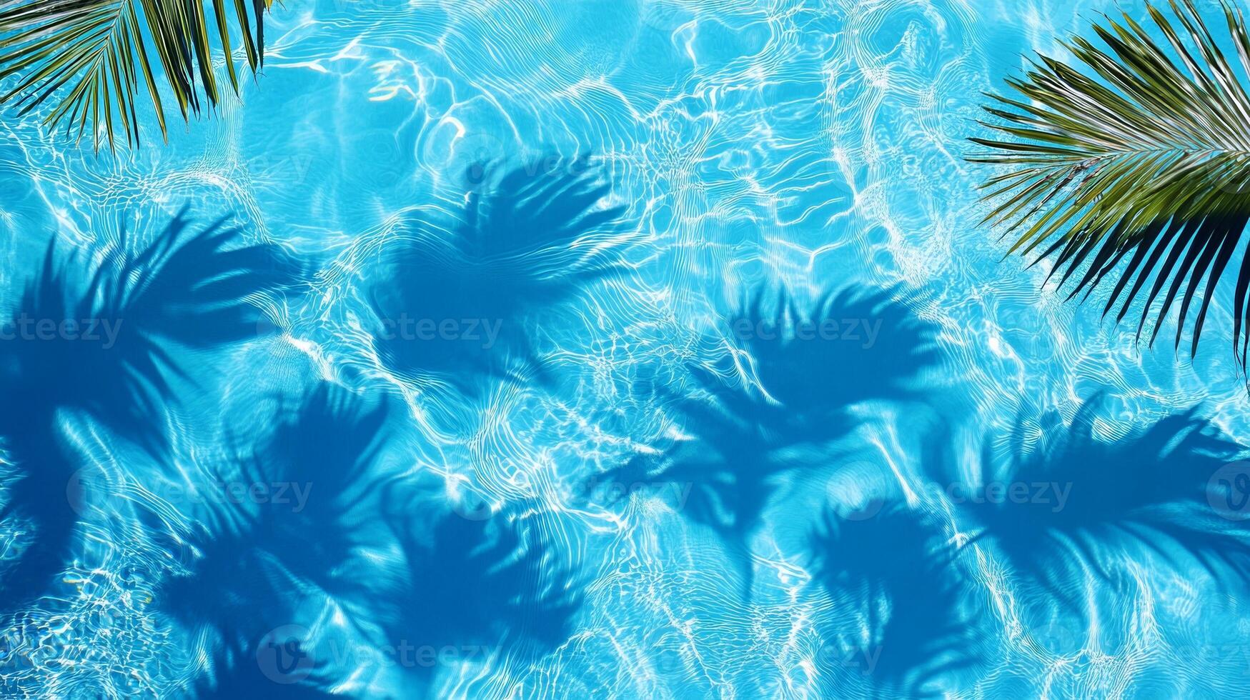 A detailed close-up of aqua waves with palm leaf shadows dancing on the surface of a bright blue pool photo