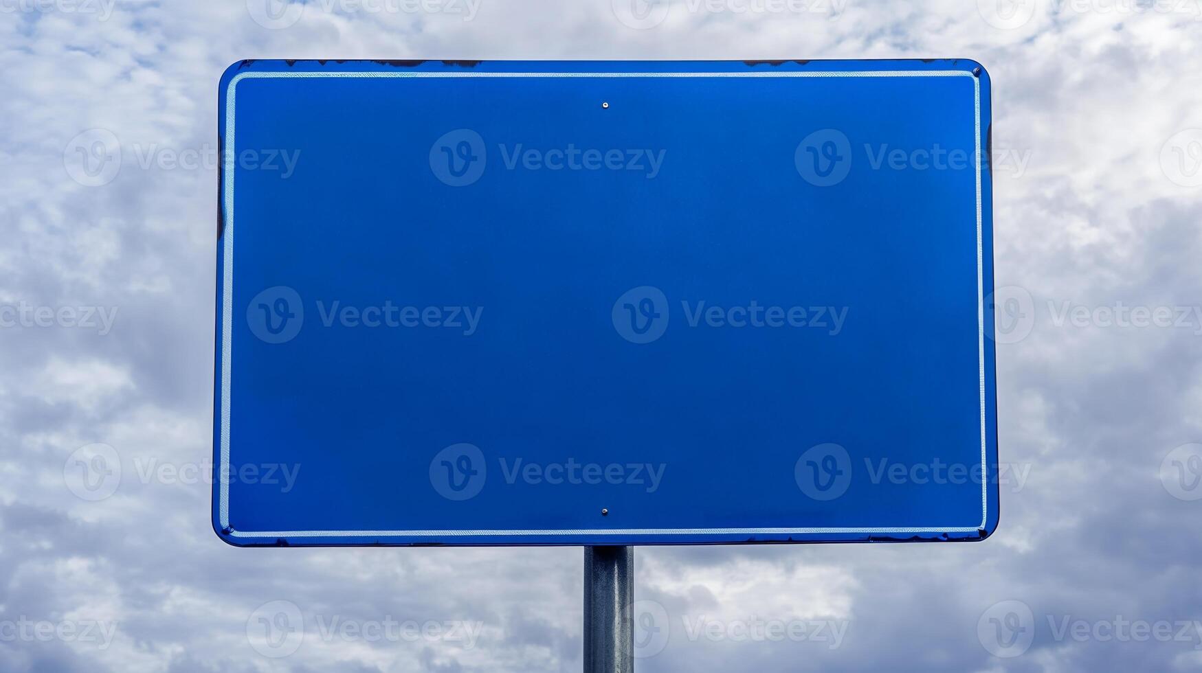 Closeup of a plain blue road sign with no text, isolated against a cloudy sky for mockup purposes photo