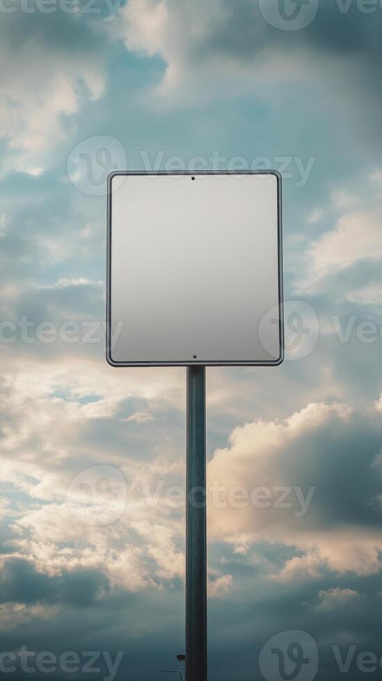 Vertical shot of a blank road sign on a tall post, isolated against a cloudy sky, mockup for text photo