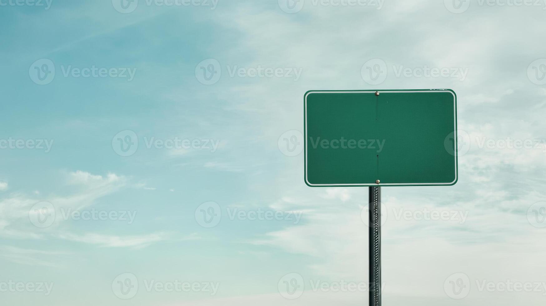 A plain green highway sign on a metal post, positioned against a wide-open sky for custom text photo