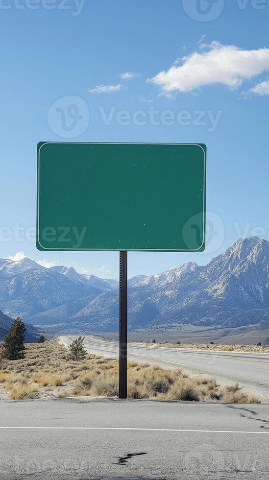 A simple green highway sign, no text, with mountains in the background, ready for custom content photo