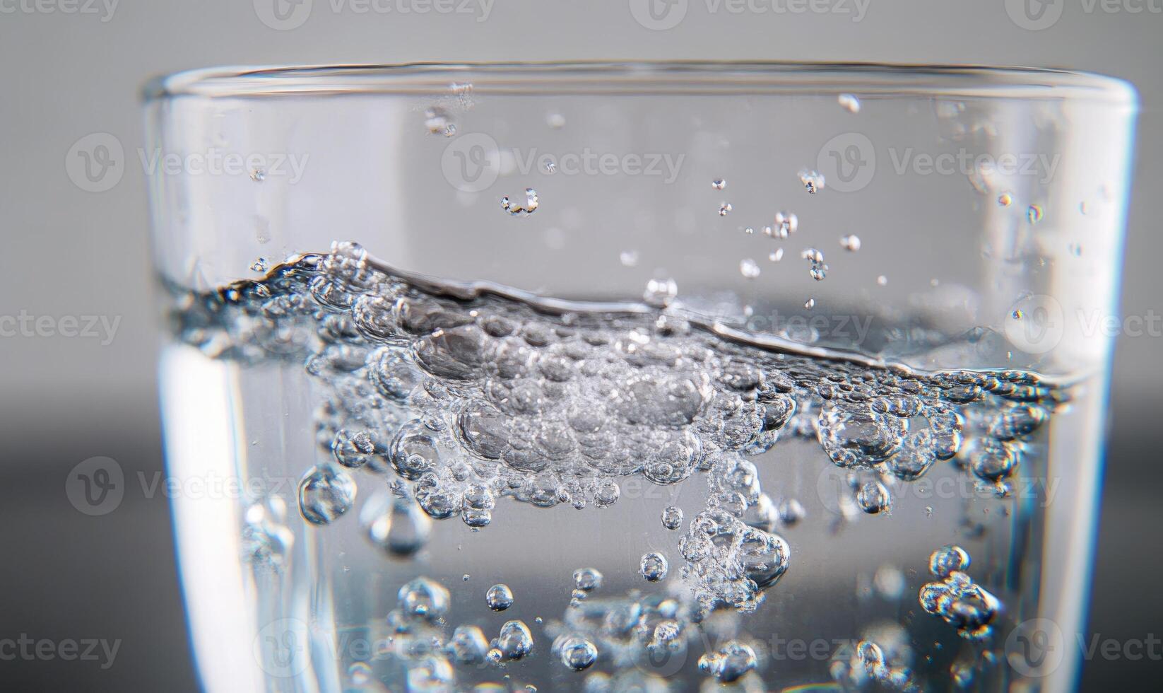 Tablet fizzing in water, bubbles ascending, close-up shot photo