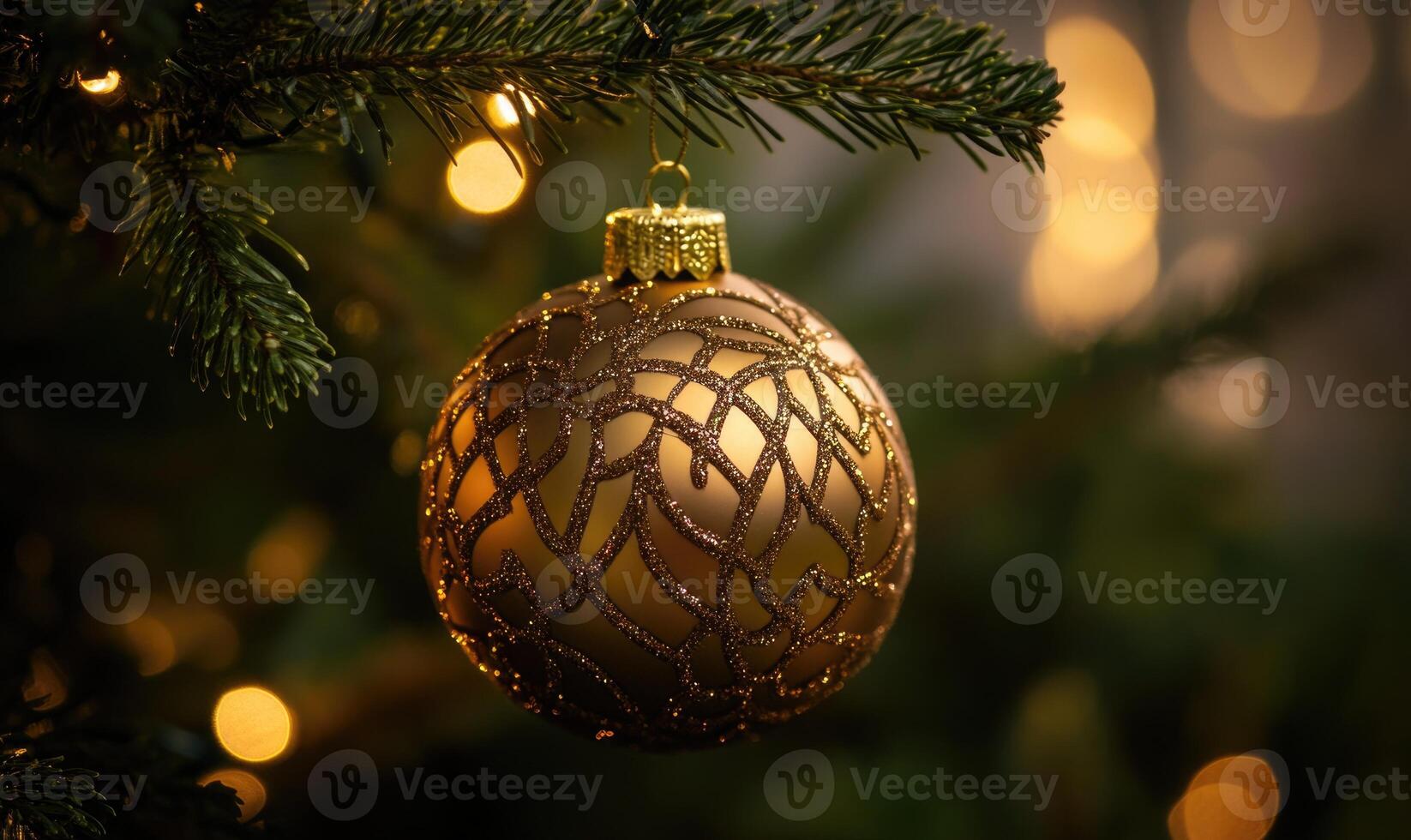 A gold ornament hanging from a Christmas tree photo