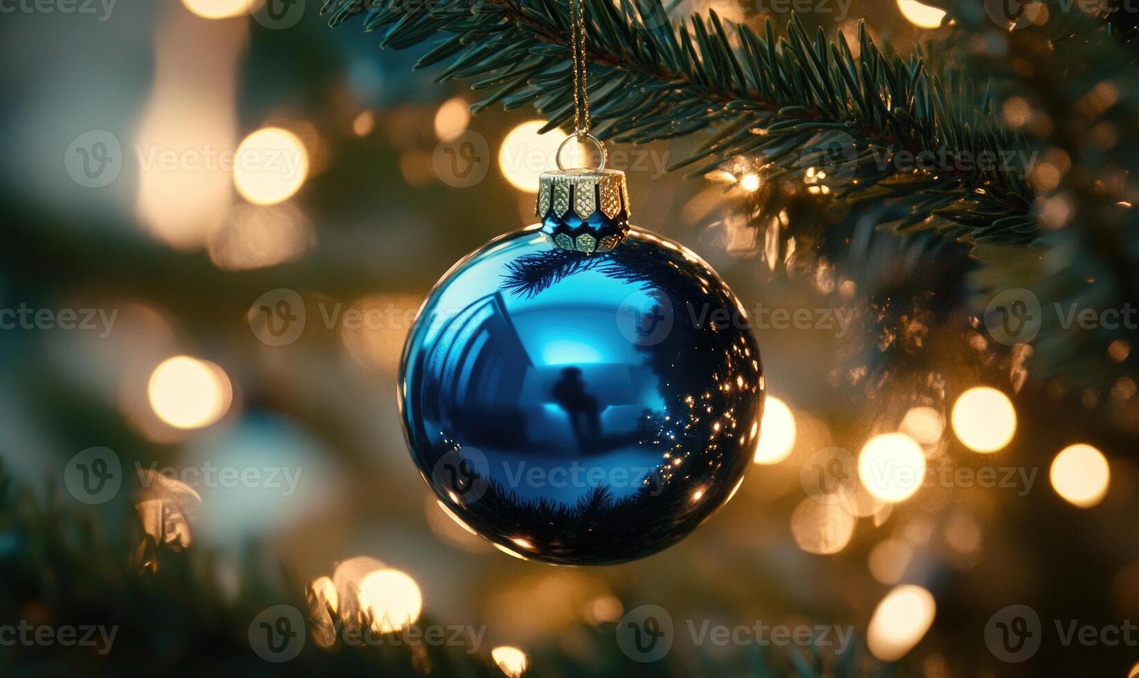 A blue Christmas ornament hanging from a tree photo
