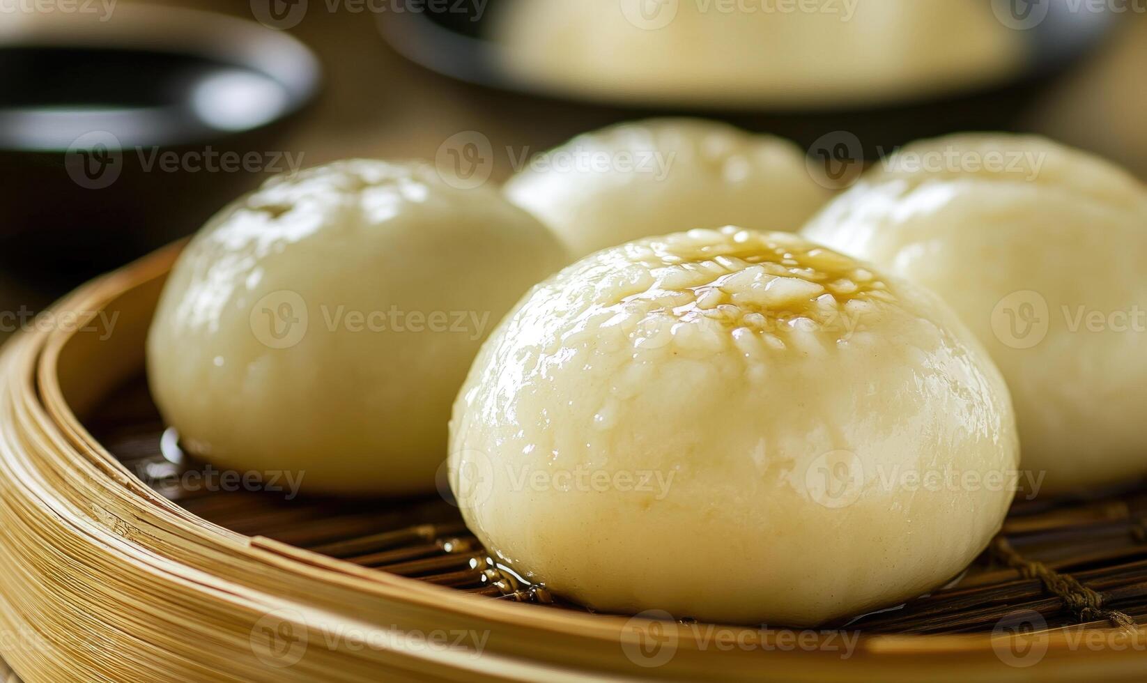 A group of four dumplings are sitting on a bamboo tray photo