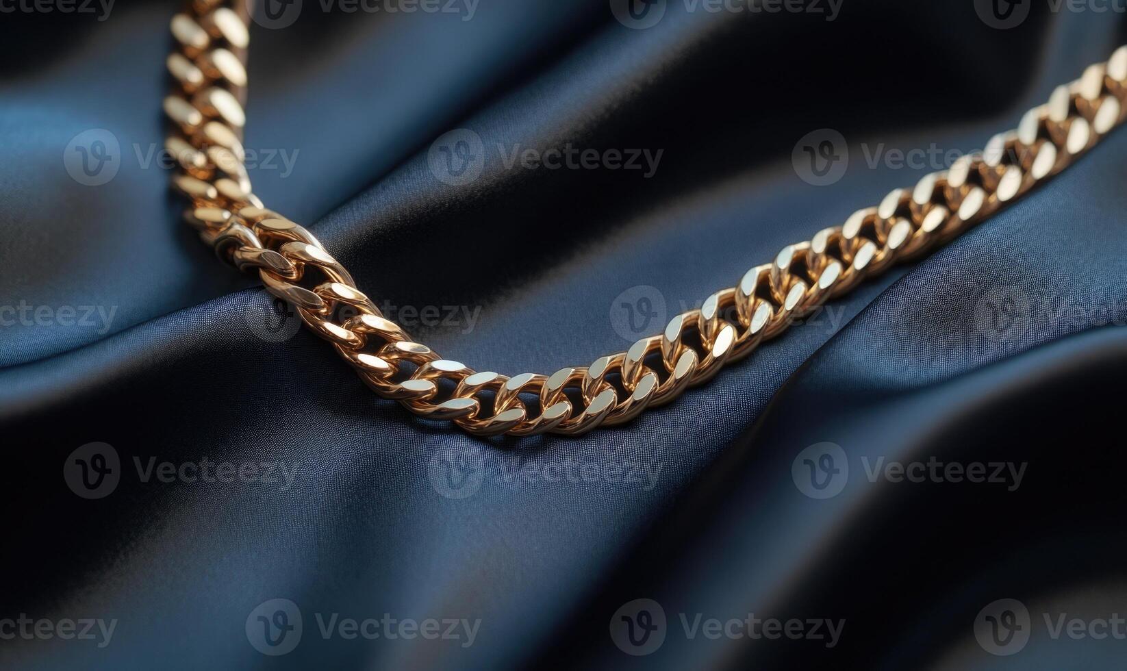 A gold chain necklace is on a black cloth photo