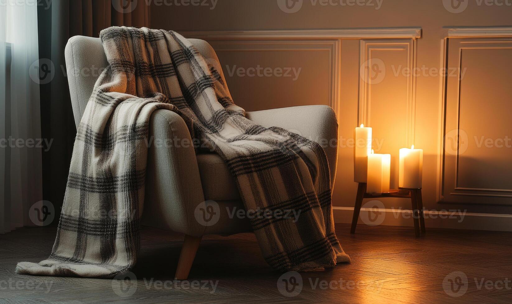 A chair is covered with a blanket and a candle is lit photo