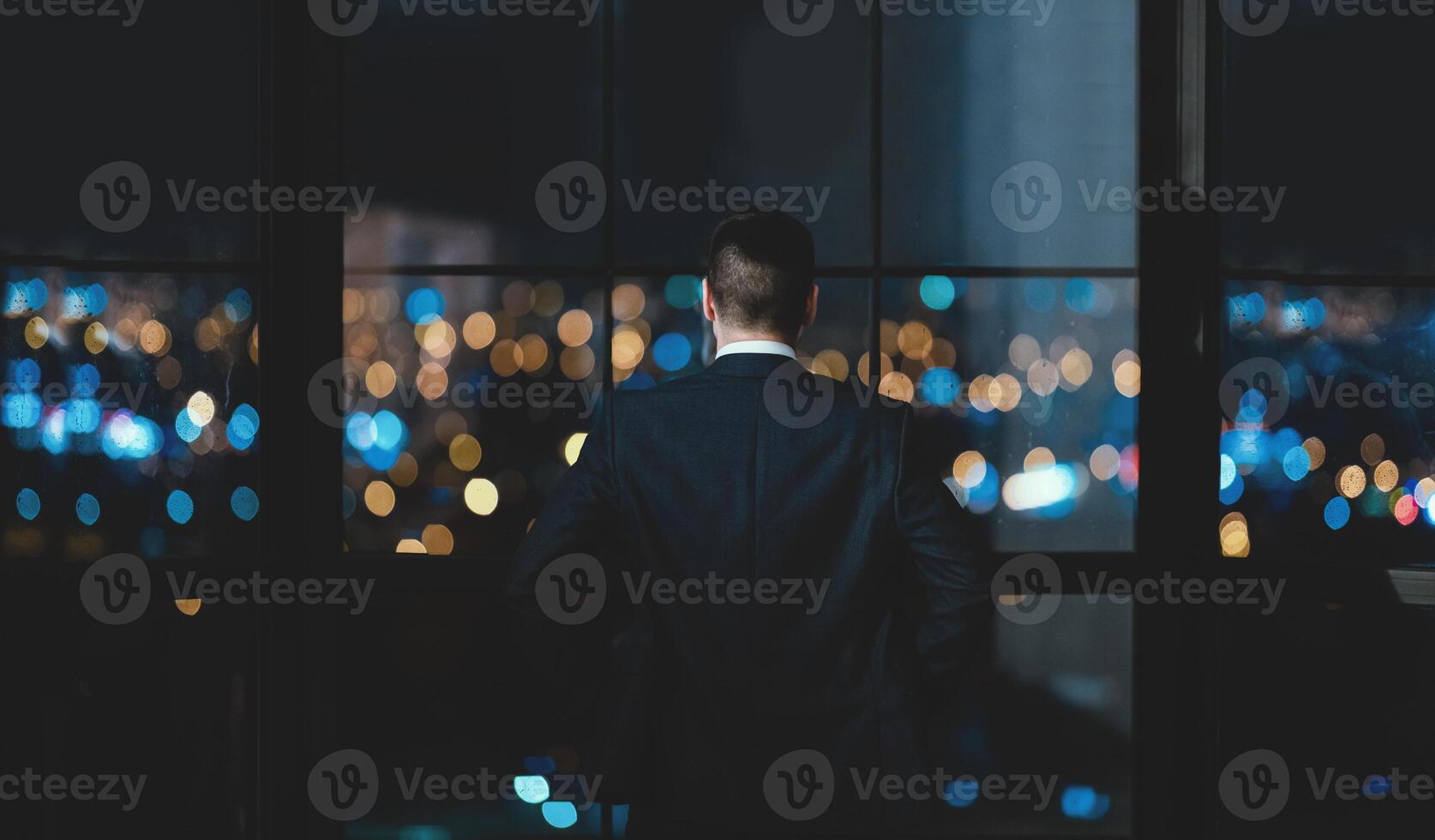 Successful Businessman Standing Near Panoramic Window Looking At Night City View In Modern Office. Business Success Concept photo