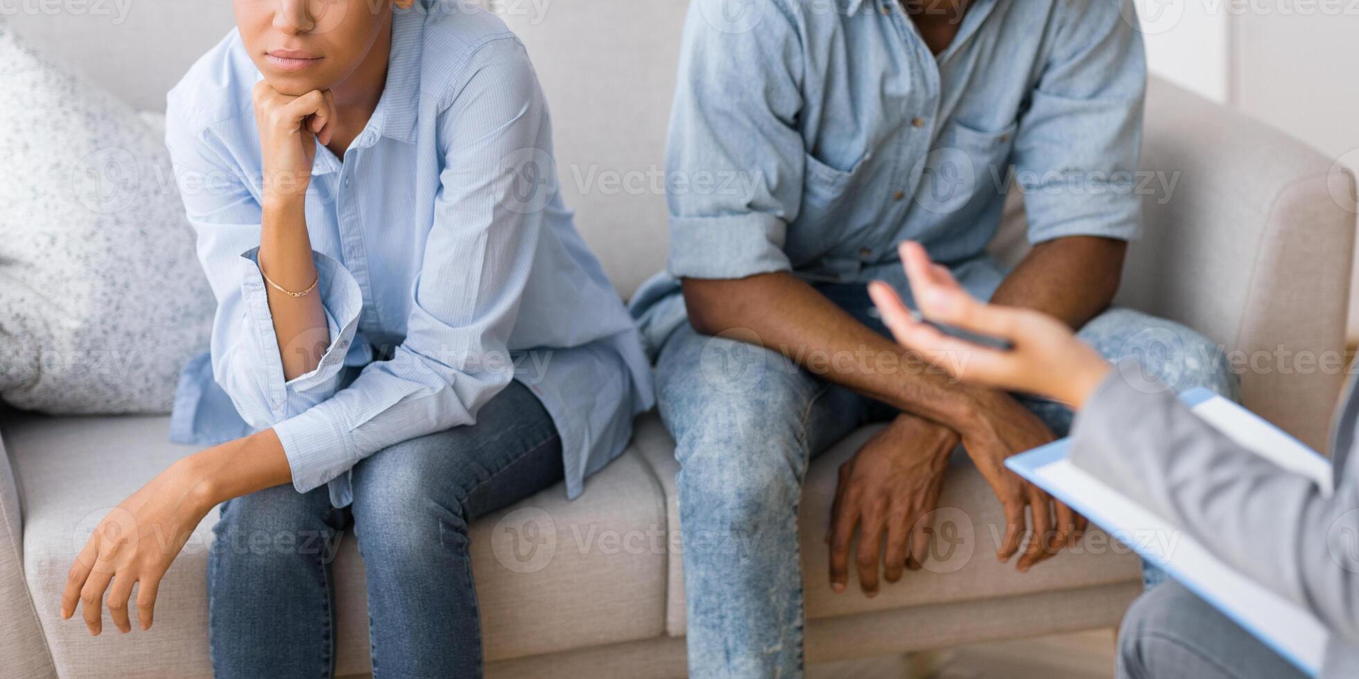 Broken Marriage And Therapy. Upset Afro Husband And Wife Avoiding Eye Contact Sitting On Sofa At Couples Therapist's Office. photo