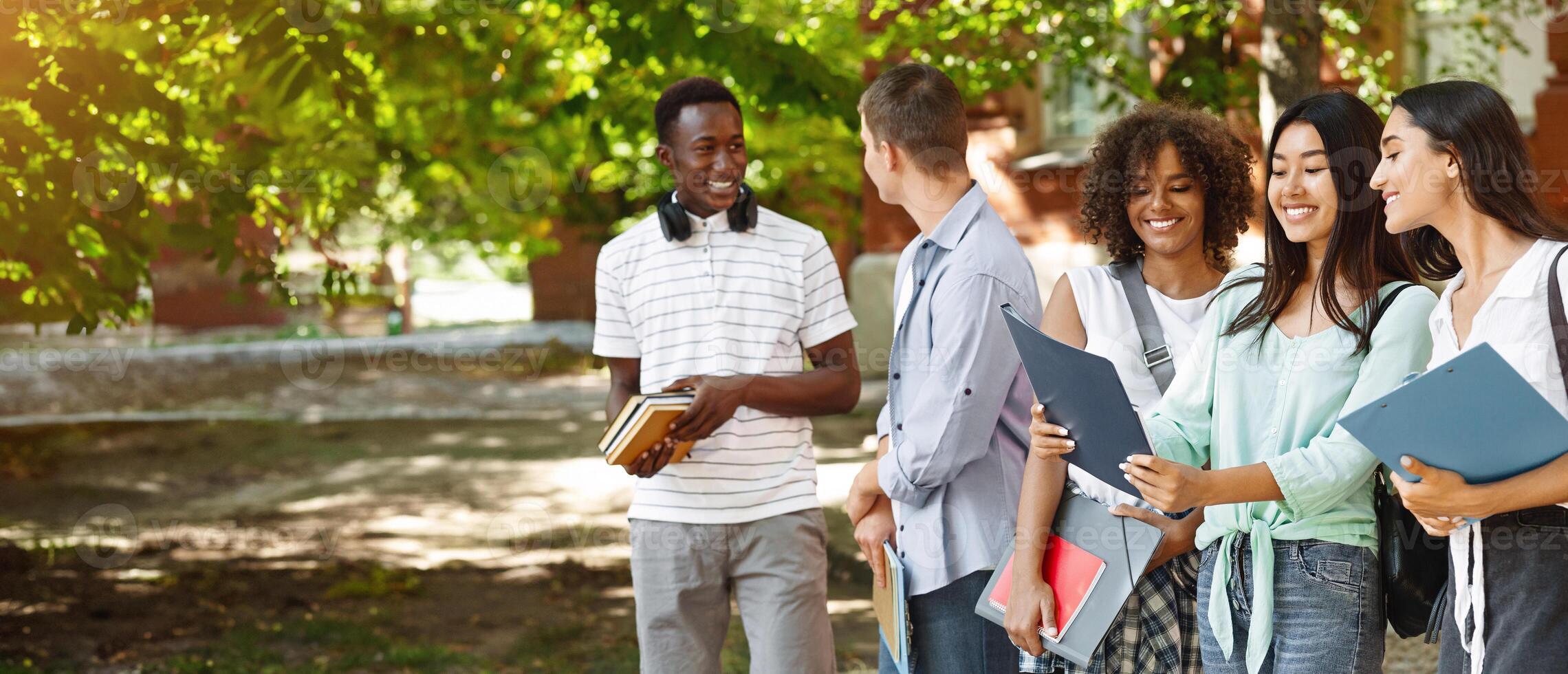 Portrait Of Smiling International Students Standing Outdoors At Campus Courtyard After Classes photo