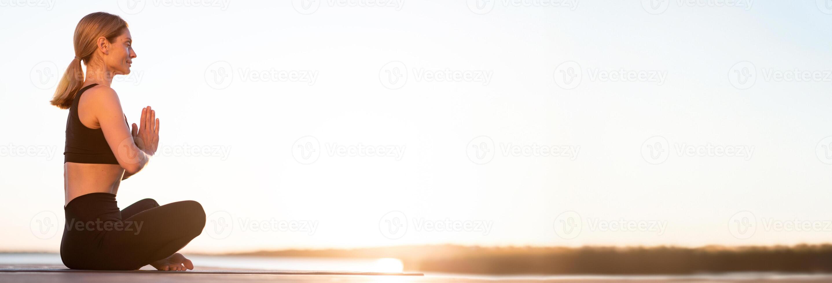 Sunset Meditation. Beautiful Calm Middle Aged Woman Meditating Outdoors, Relaxed Smiling Lady Sitting With Closed Eyes And Keeping Hands In Namaste Gesture, Practicing Yoga Outside, Copy Space photo