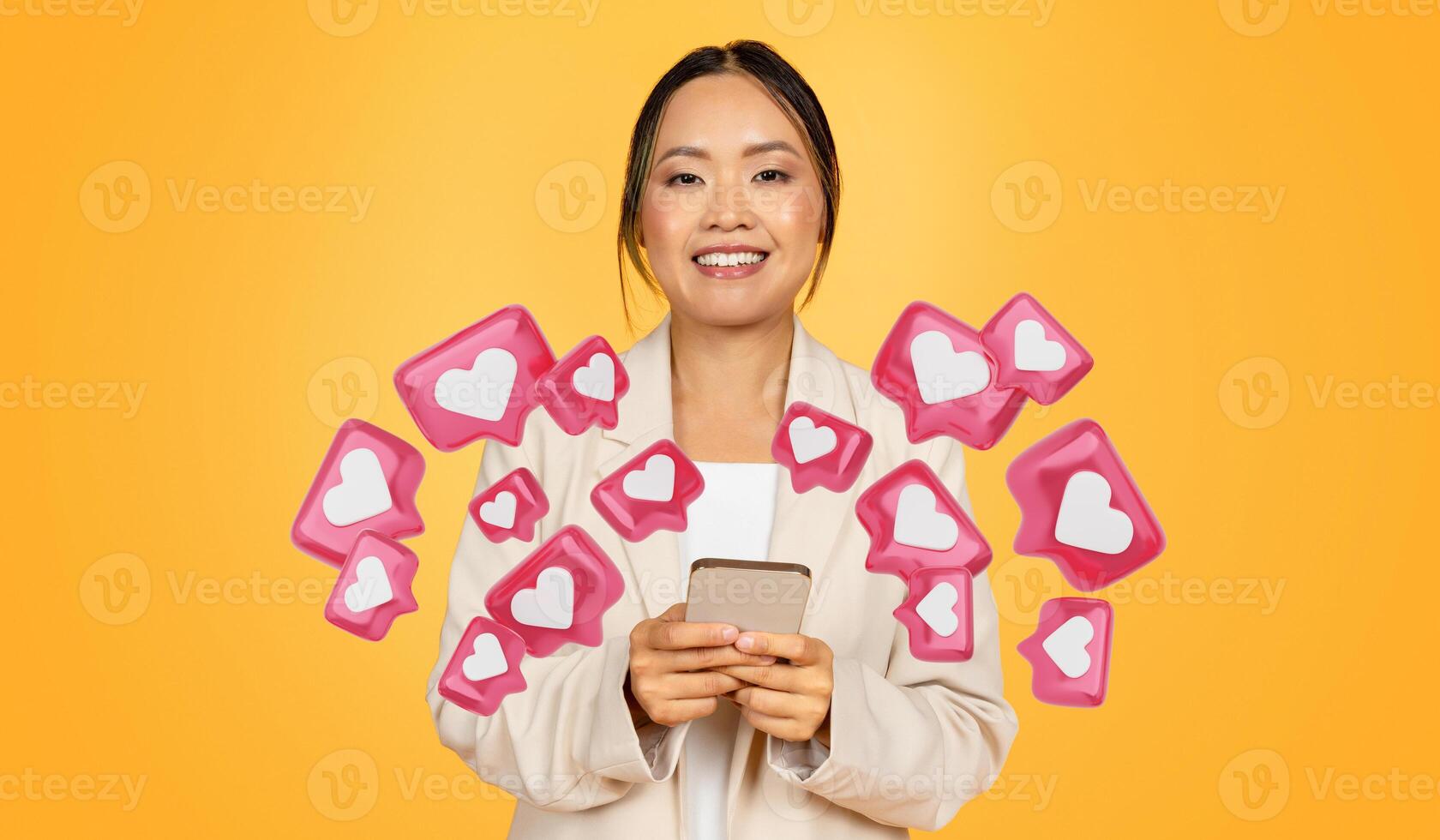 Glad millennial chinese businesswoman in suit, typing on smartphone, chatting with lover, isolated on orange studio background. Dating app photo