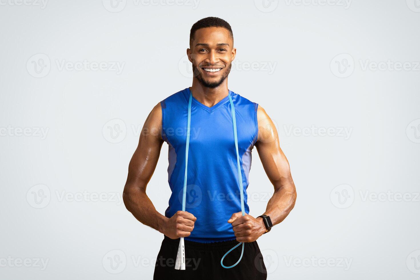 Workout Concept. Happy black man with jumping rope on neck isolated over yellow background. Copyspace photo