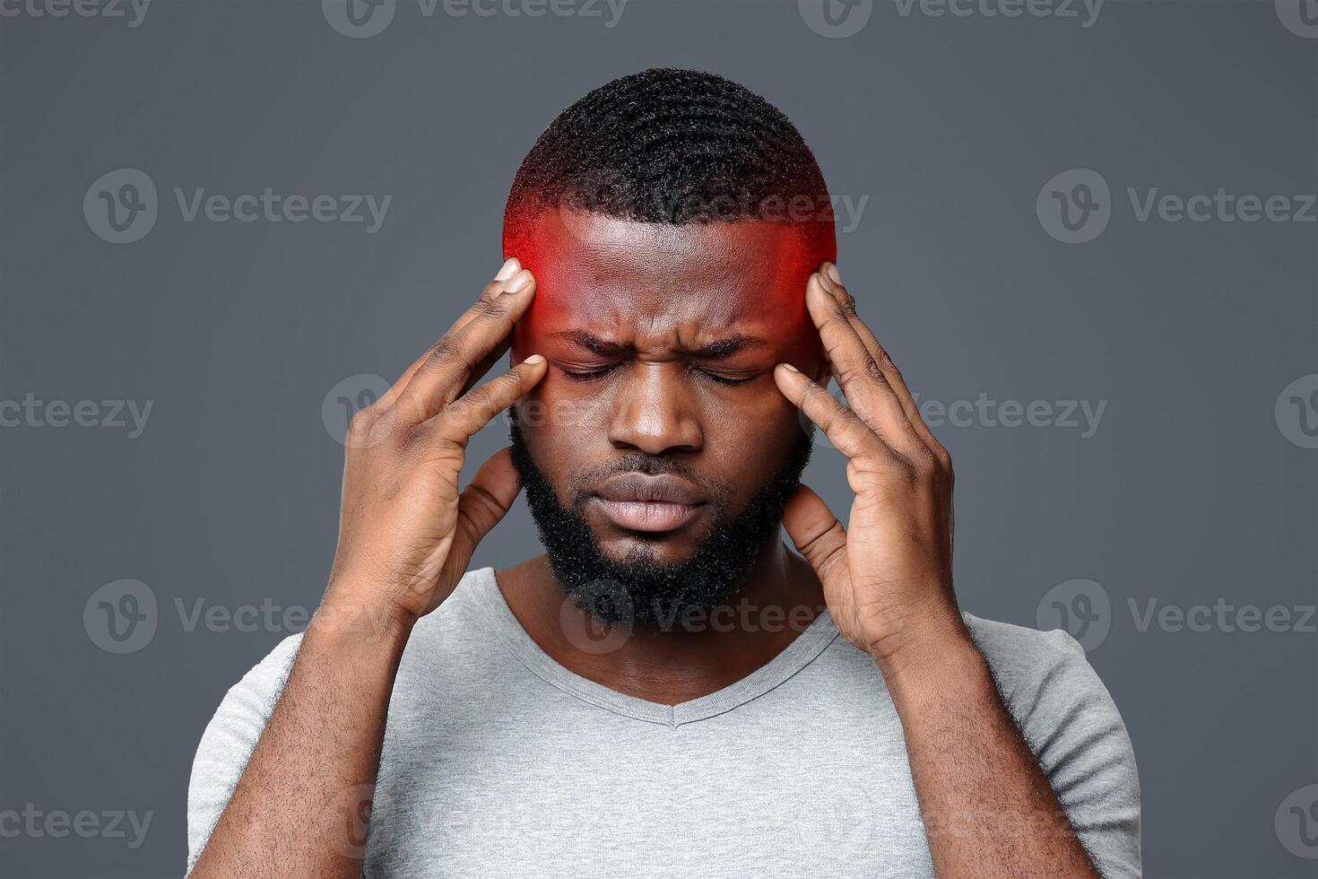 Young afro man having headache, touching his highlighted temples, migraine concept photo