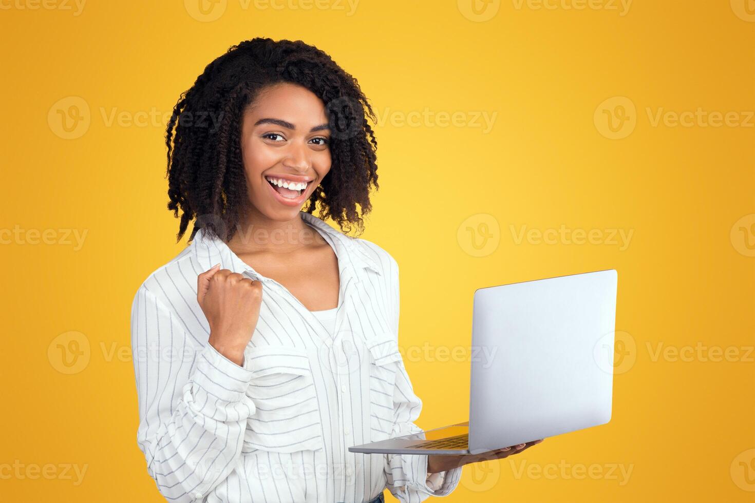 Well Done. Excited african american woman celebrating online win, great deal or business success using laptop photo