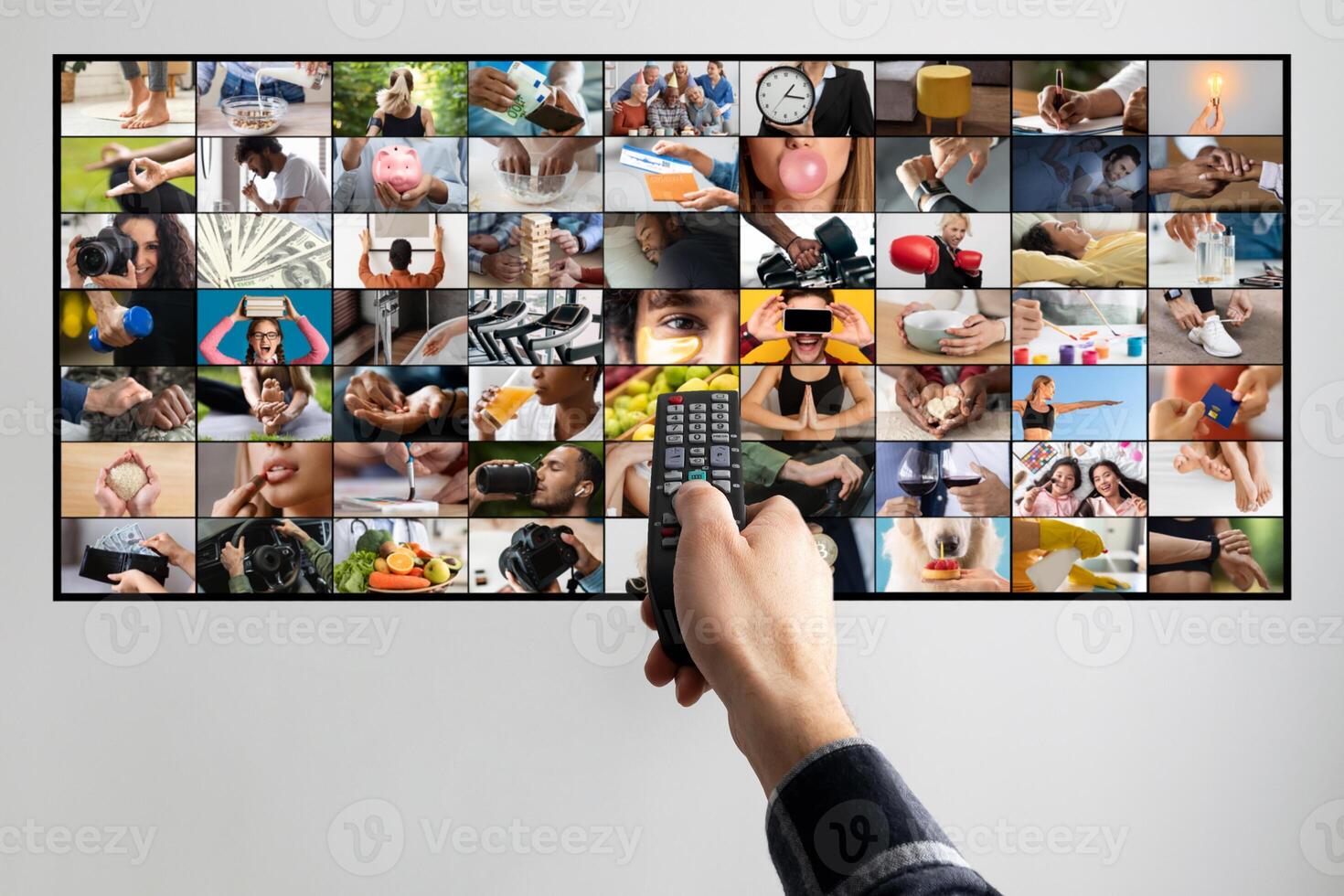 A persons hand is shown holding a remote control, pointing at a television screen. The television screen displays a collage of various images, each depicting a different activity or scene. photo