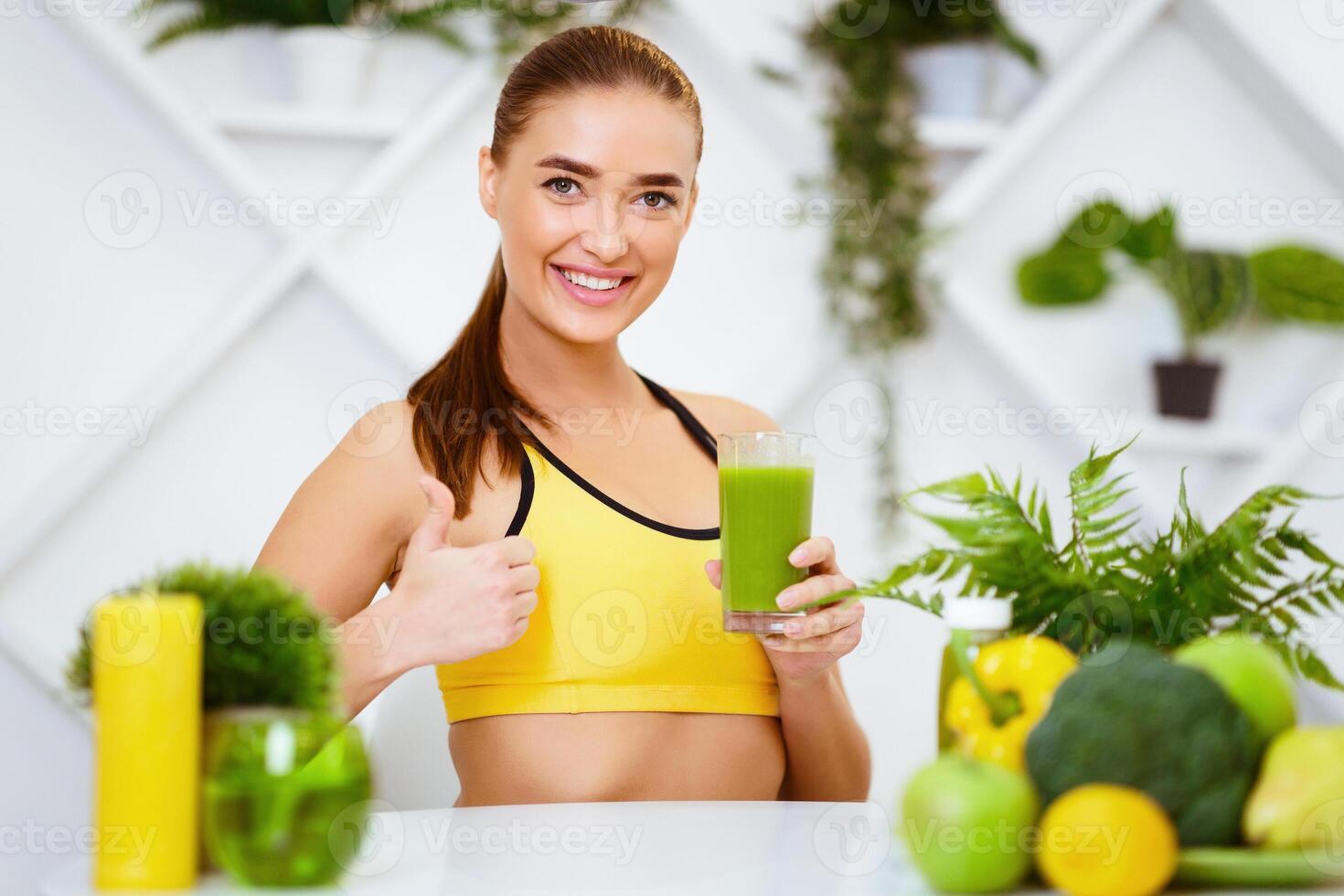 Healthy Diet. Fit Girl Showing Thumb Up For Green Smoothie, Cooking At Kitchen photo