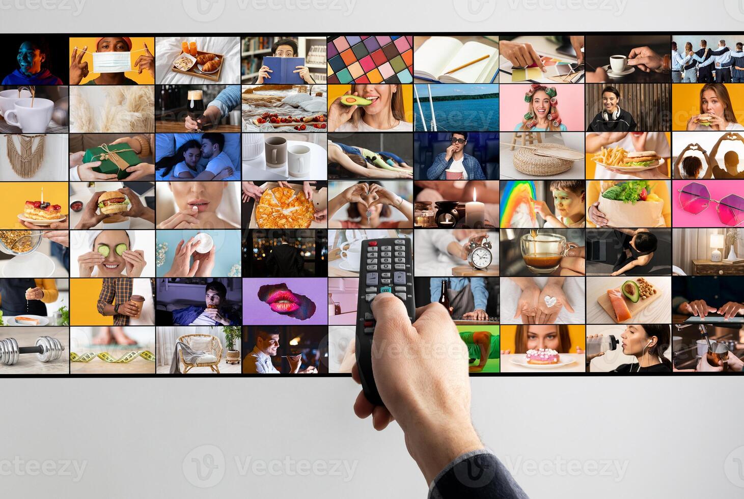 A hand holds a black remote control in front of a large television screen displaying a variety of images in a grid format. The images showcase everyday activities, objects, and people photo