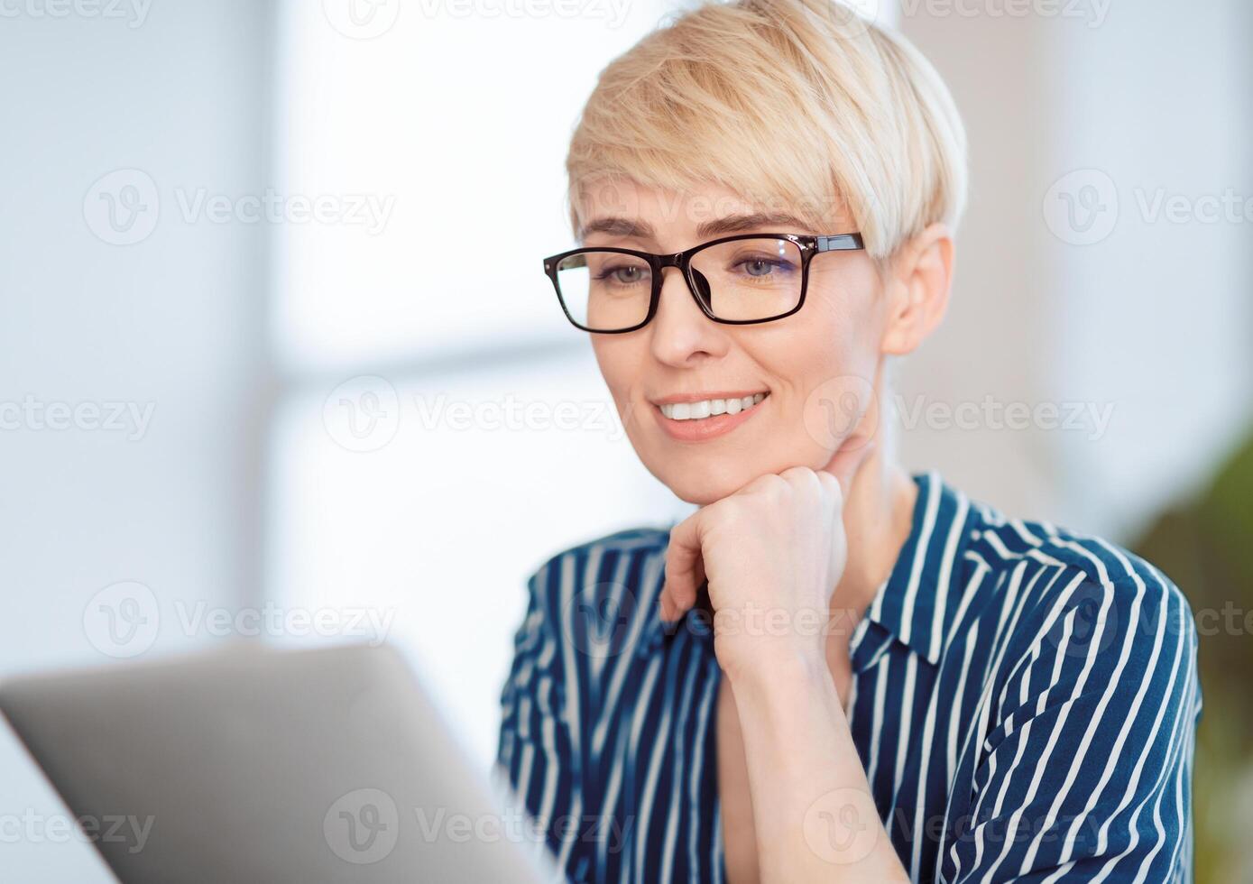 Happy Businesswoman Reading Business News On Digital Tablet Computer Sitting In Modern Office. Selective Focus photo
