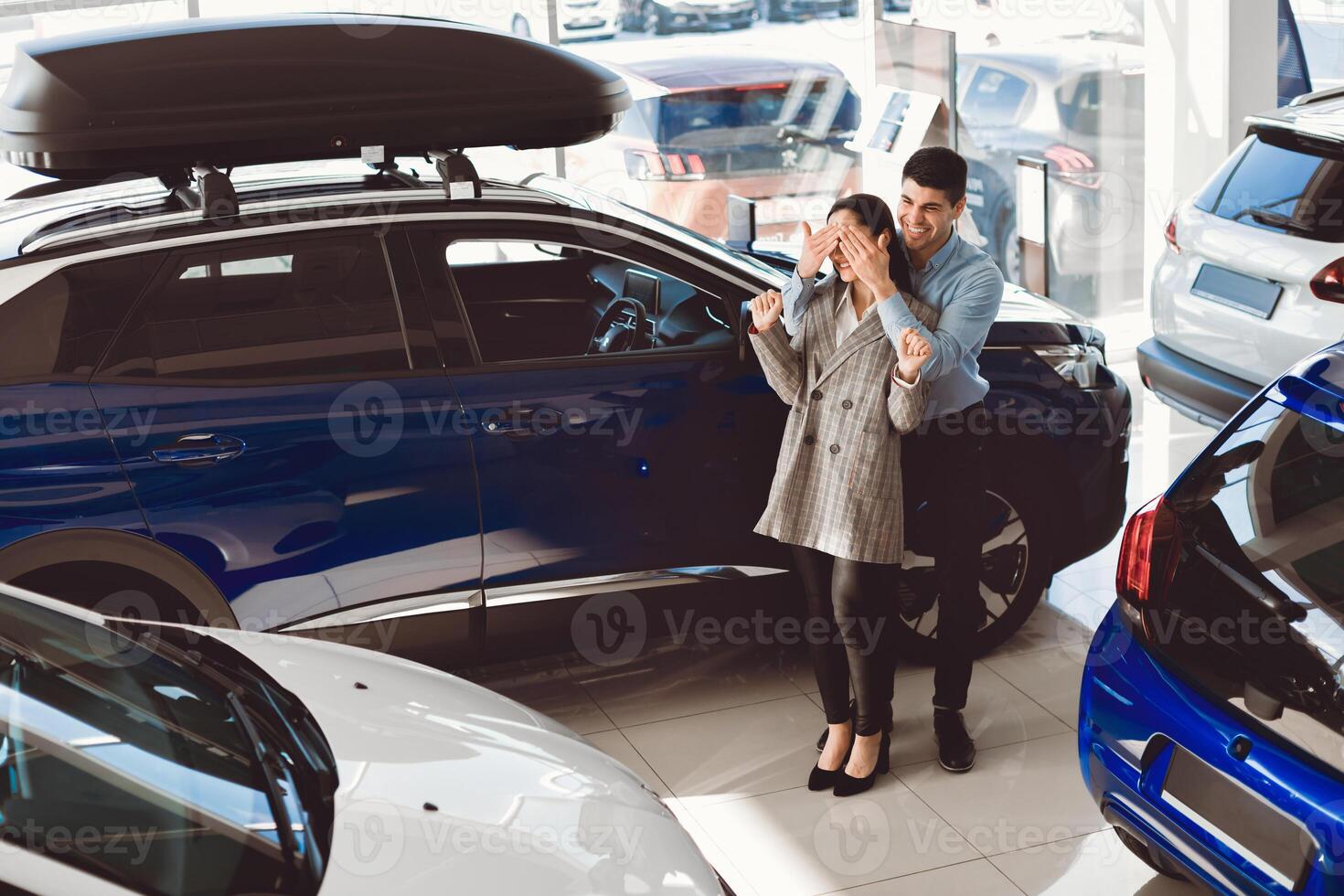 Surprise. Loving Husband Covering Wife's Eyes Before Showing Her Automobile Standing In Auto Dealership Center photo