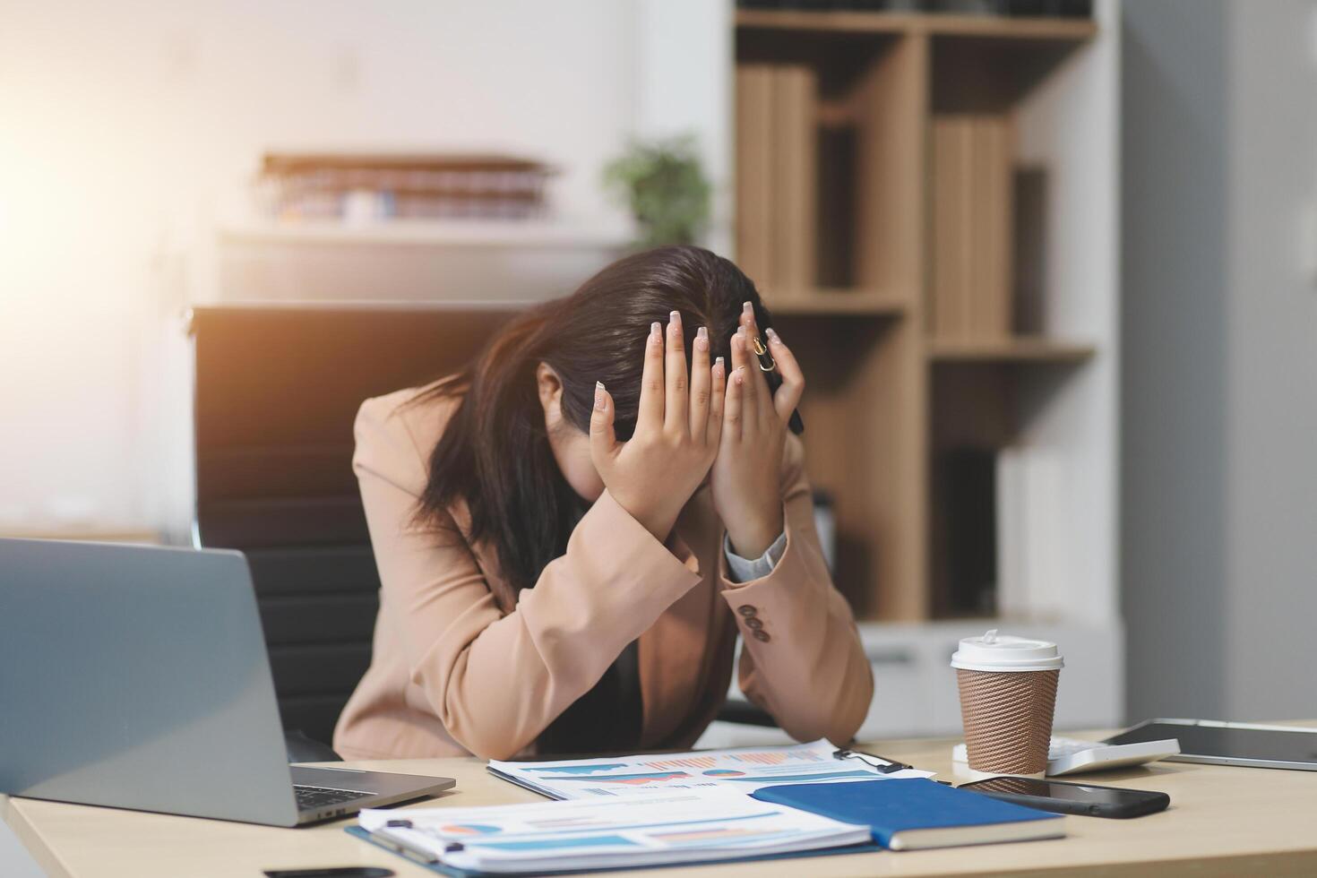 Portrait of tired young business Asian woman work with documents tax laptop computer in office. Sad, unhappy, Worried, Depression, or employee life stress concept photo