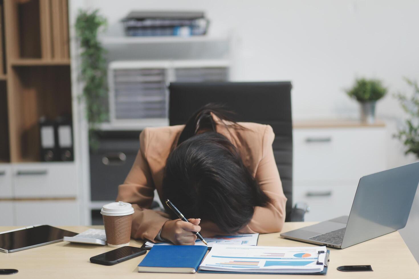 Portrait of tired young business Asian woman work with documents tax laptop computer in office. Sad, unhappy, Worried, Depression, or employee life stress concept photo