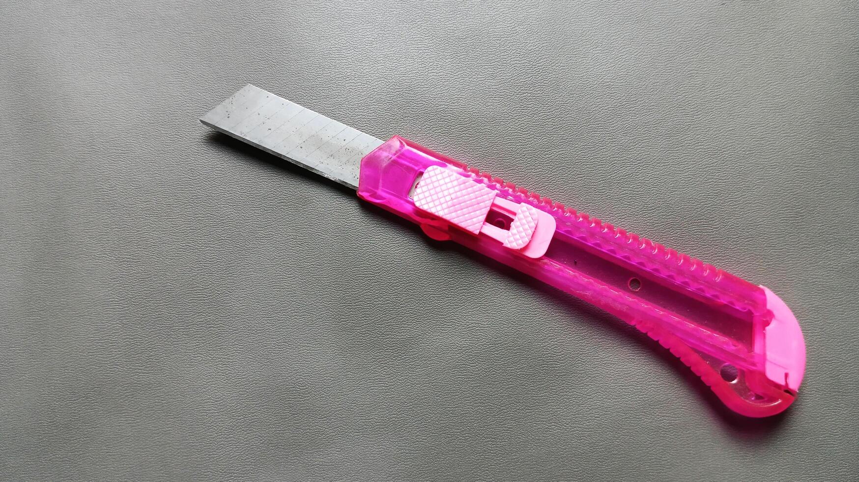 Pink cutting knife isolated on gray photo
