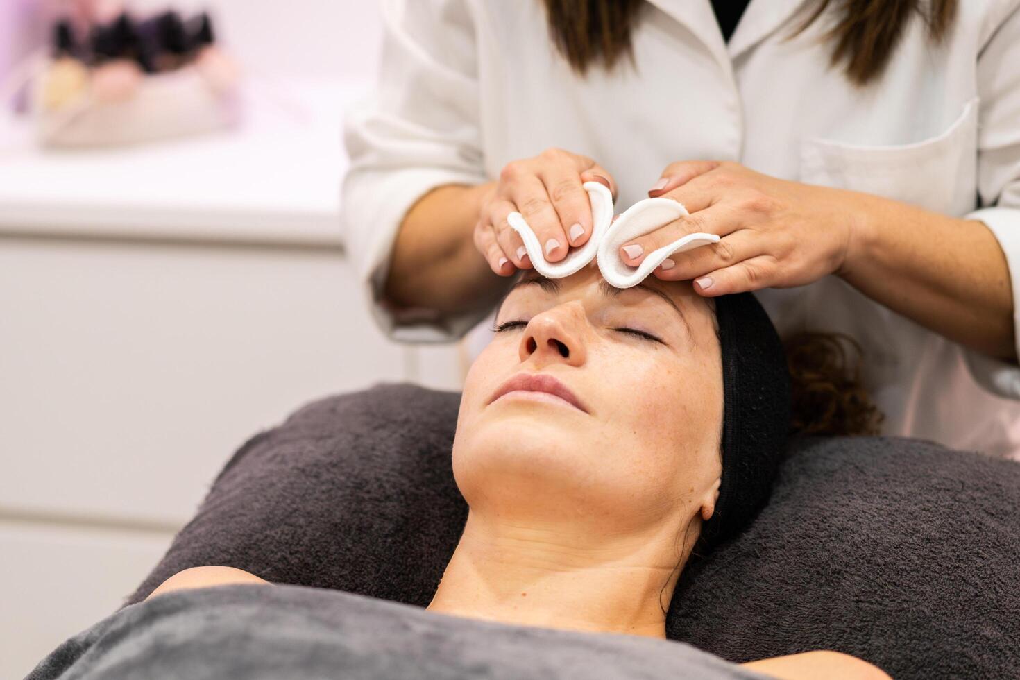 Relaxed woman receiving professional beauty treatment in spa photo