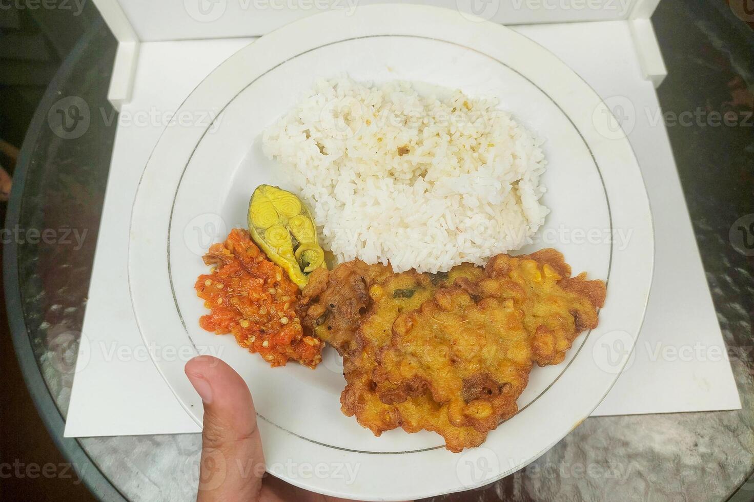 Rice mixed with fried fish and tempeh vegetables on a white plate photo